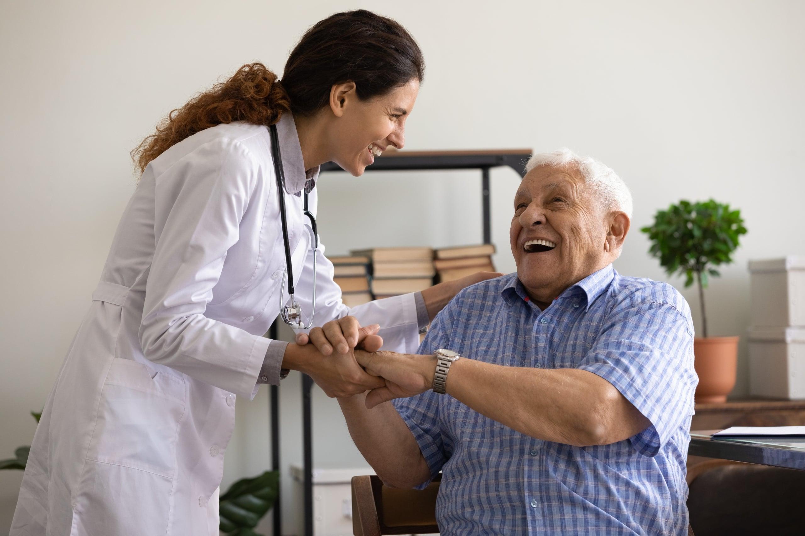 一位老人和一位微笑的年轻护士在一起大笑